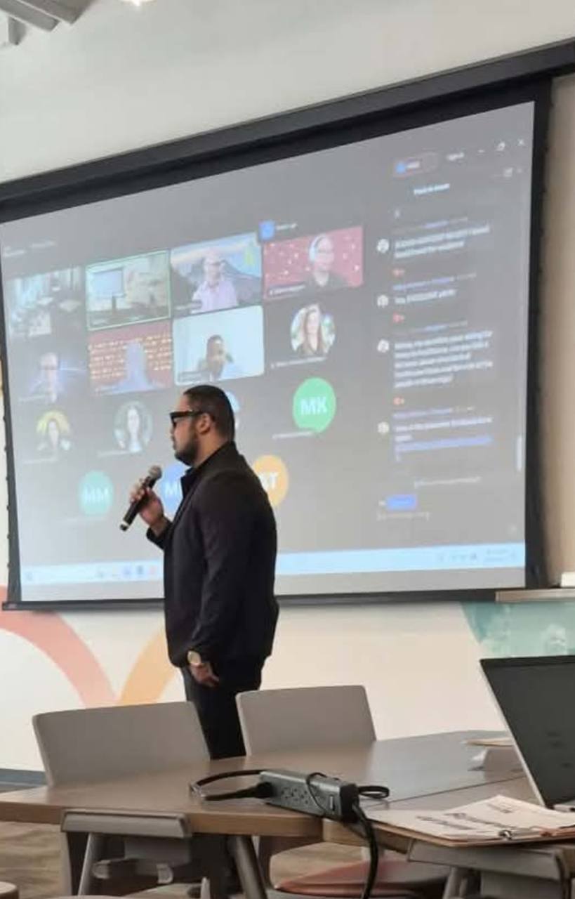A speaker holding a microphone in front of a projected video call